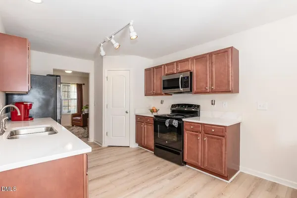 a kitchen with a sink stove top oven and refrigerator