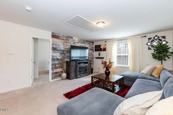 a living room with furniture kitchen view and a window