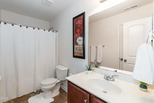 a bathroom with a sink a toilet and mirror