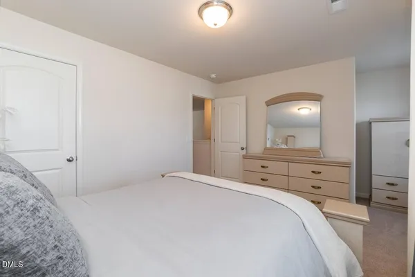 a bedroom with a bed and a mirror