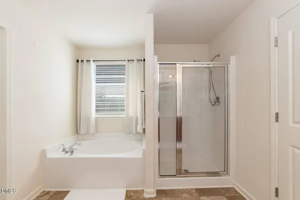 a bathroom with a bathtub a shower and a sink