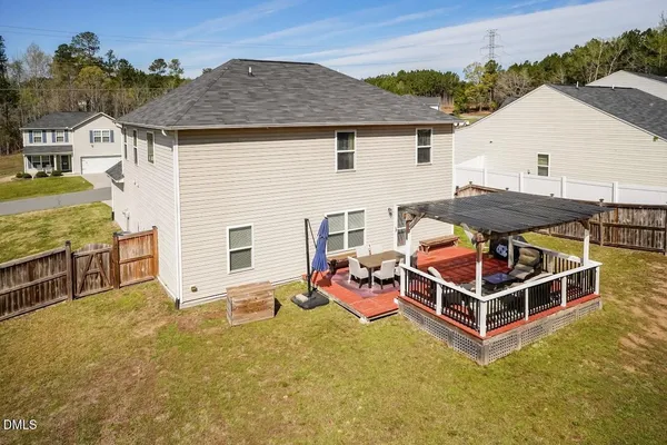 a view of a house with a barbeque and wooden fence
