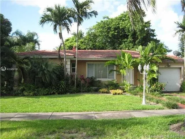 a front view of a house with a yard and potted plants