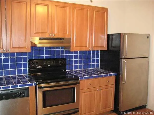 a kitchen with granite countertop a stove a refrigerator and a sink