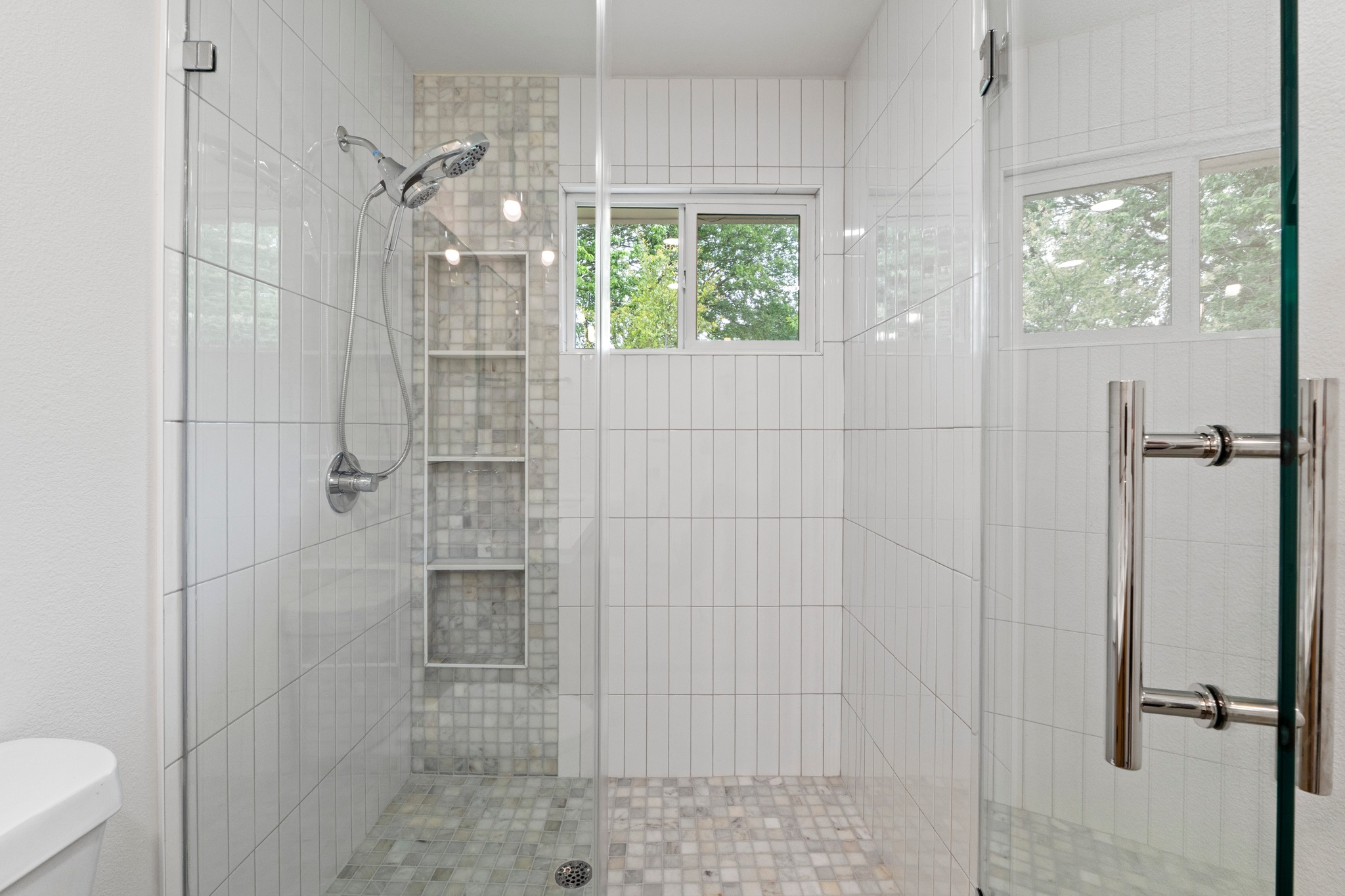 1608 Springer Lane Austin, TX 78758 - Photo 31 of 35 Frameless glass shower enclosure featuring a handheld showerhead and built-in tiled niches