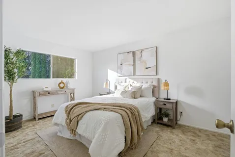 a bedroom with a bed and a large window