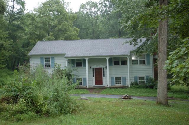 12 Howes Lane Redding, CT 06896 - Photo 1 of 1 a view of a brick house with a big yard and large trees