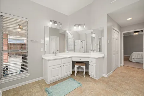a spacious bathroom with a double vanity sink a mirror and a shower