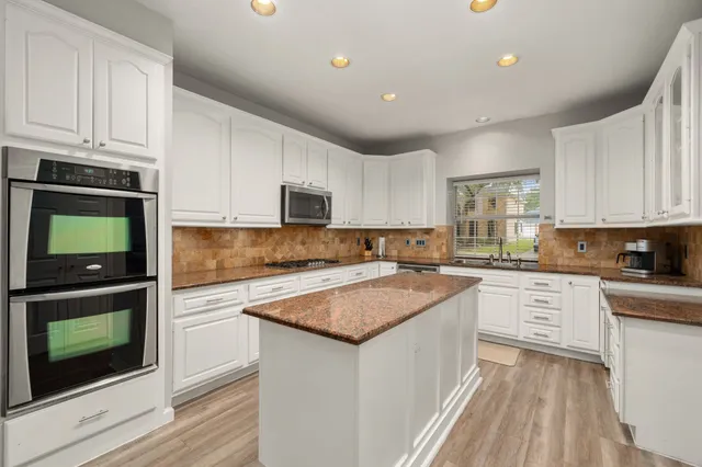 a kitchen with granite countertop white cabinets and white appliances