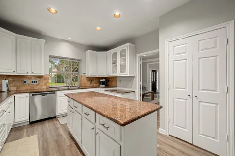 a kitchen with granite countertop white cabinets and white appliances