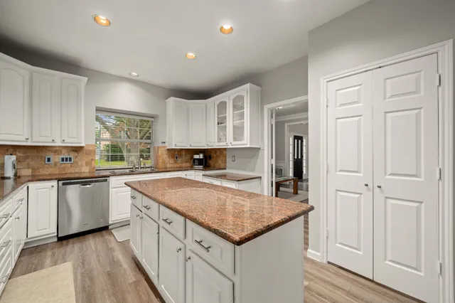 a kitchen with granite countertop white cabinets and white appliances