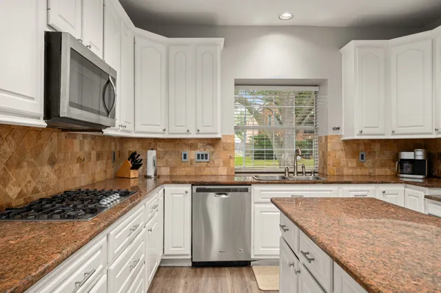 a kitchen with a sink stove top oven and cabinets