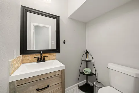 a bathroom with a toilet a sink and mirror