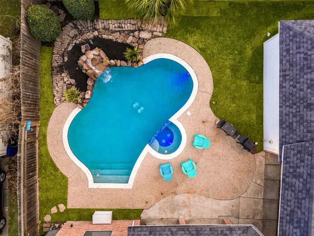 an aerial view of a house with swimming pool and outdoor space