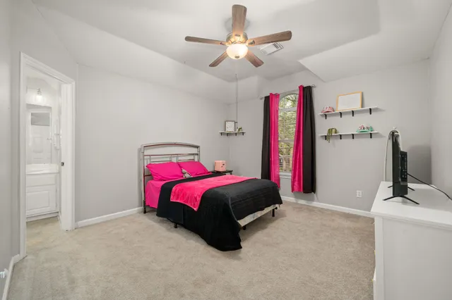 a spacious bedroom with a bed and a chandelier