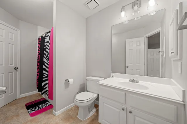 a bathroom with a sink vanity mirror and toilet