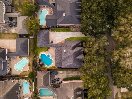 an aerial view of a house with a yard and a large tree