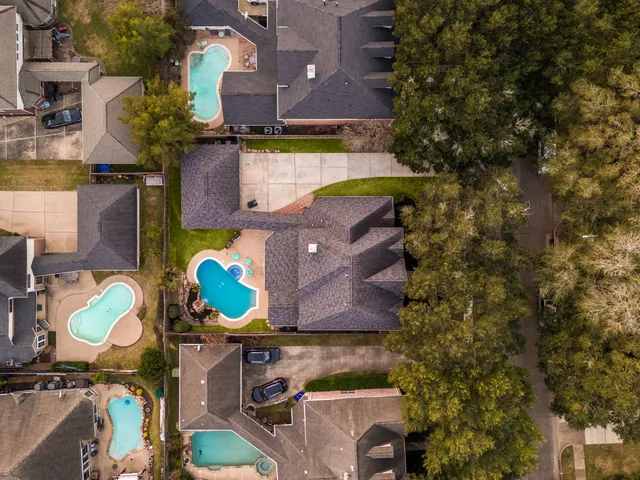 an aerial view of a house with a yard and a large tree