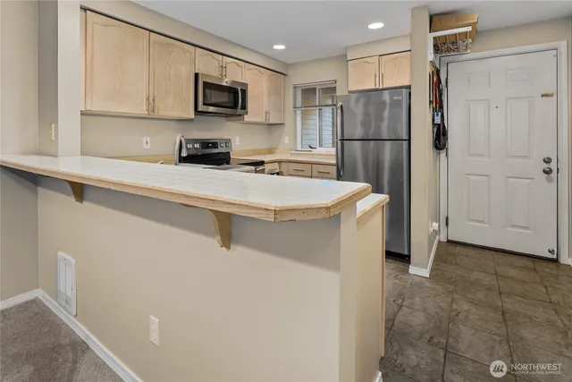 a kitchen with stainless steel appliances a refrigerator sink and microwave