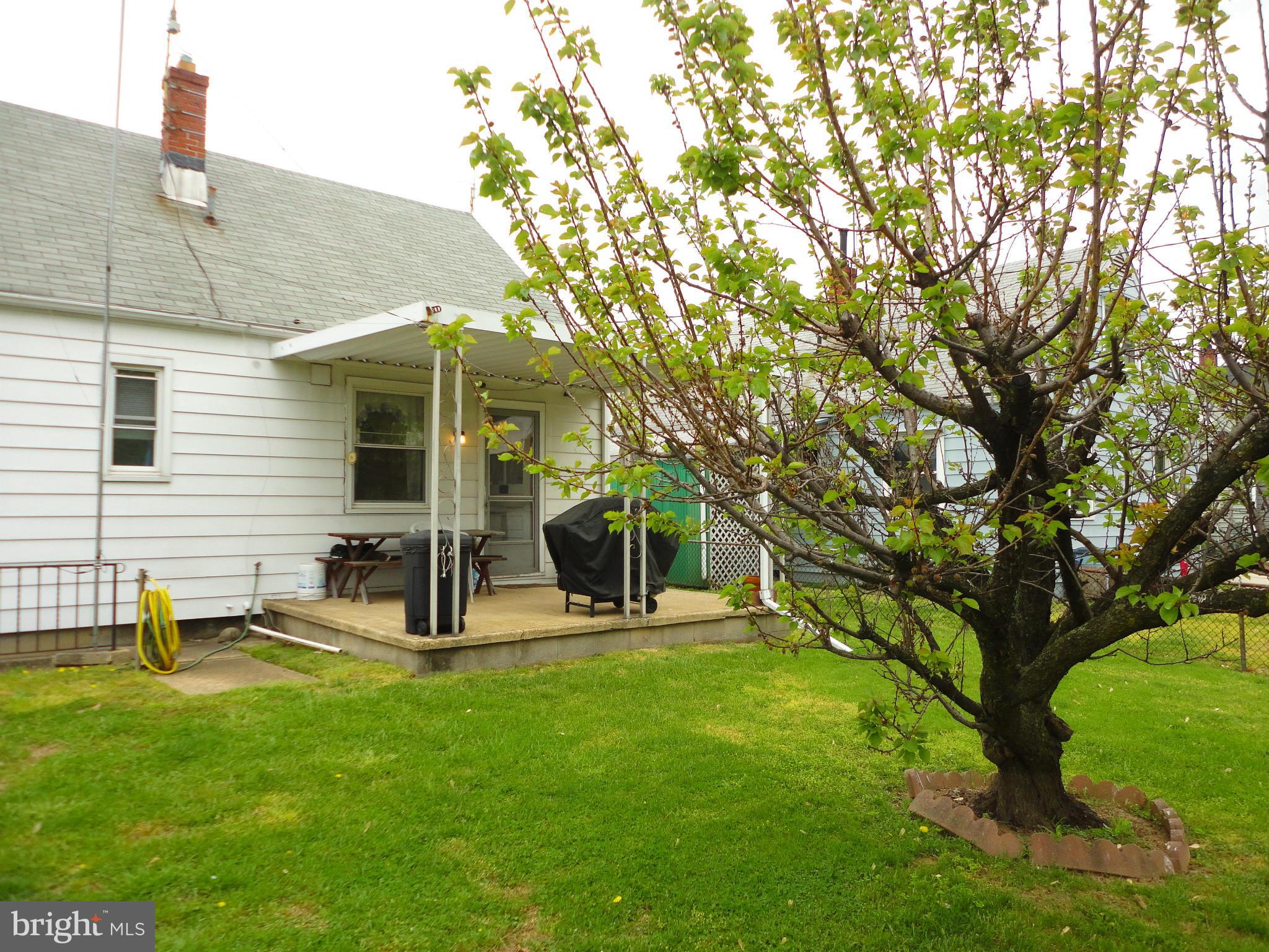 7403 Belclare Road Baltimore, MD 21222 - Photo 22 of 24 a view of a backyard with table and chairs and a large tree