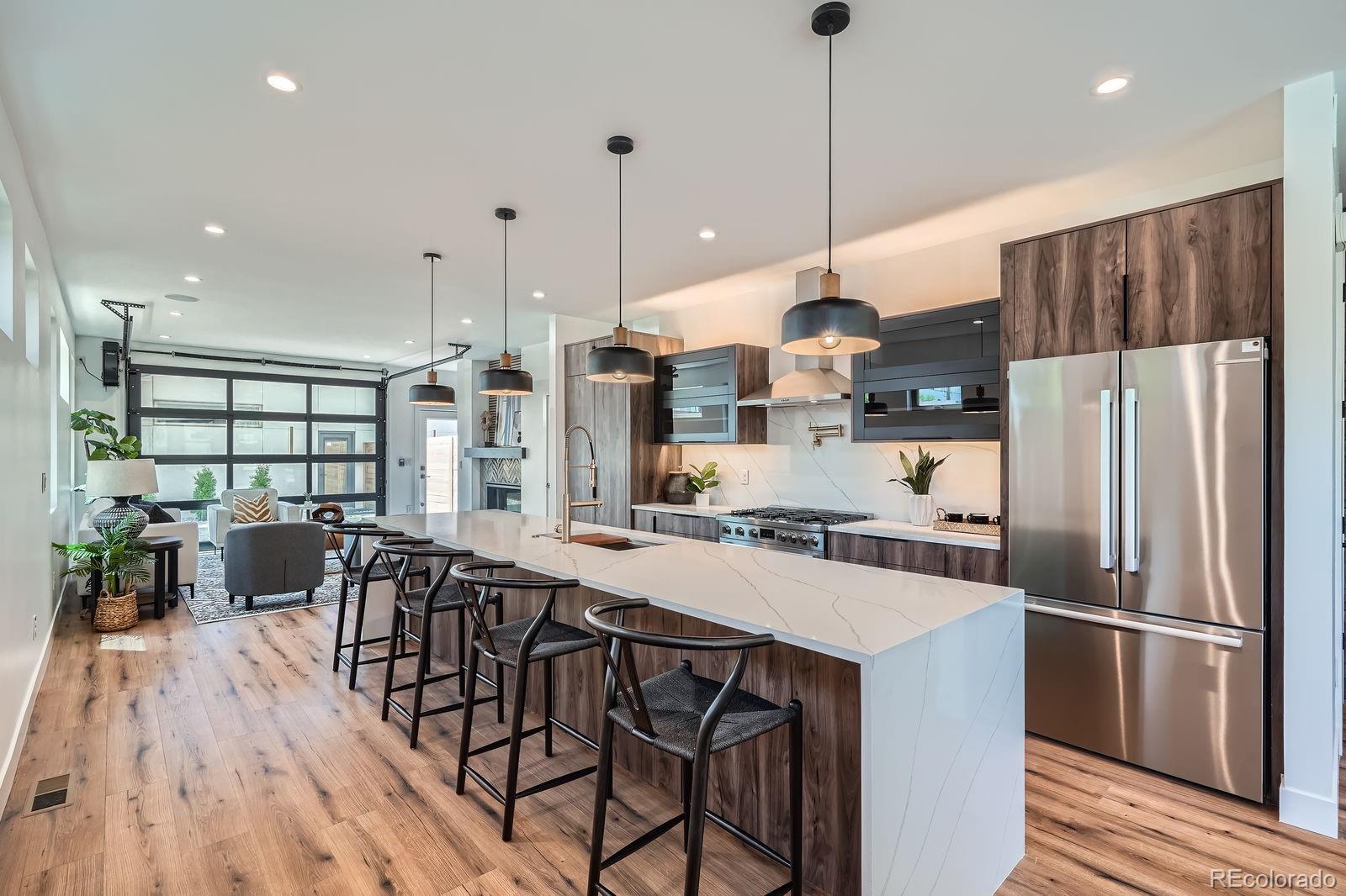 4474 Utica Street Denver, CO 80212 - Photo 11 of 40 a kitchen with stainless steel appliances a dining table chairs stove refrigerator and wooden floor