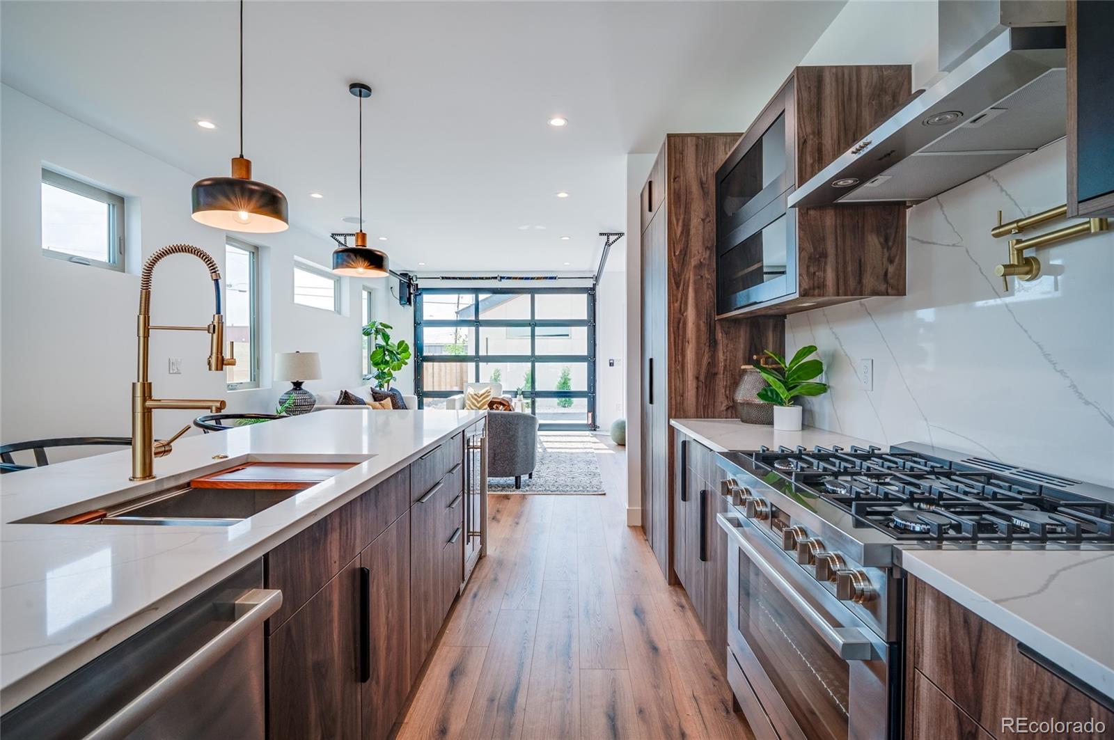 4474 Utica Street Denver, CO 80212 - Photo 12 of 40 a kitchen with kitchen island granite countertop a sink a counter space and stainless steel appliances