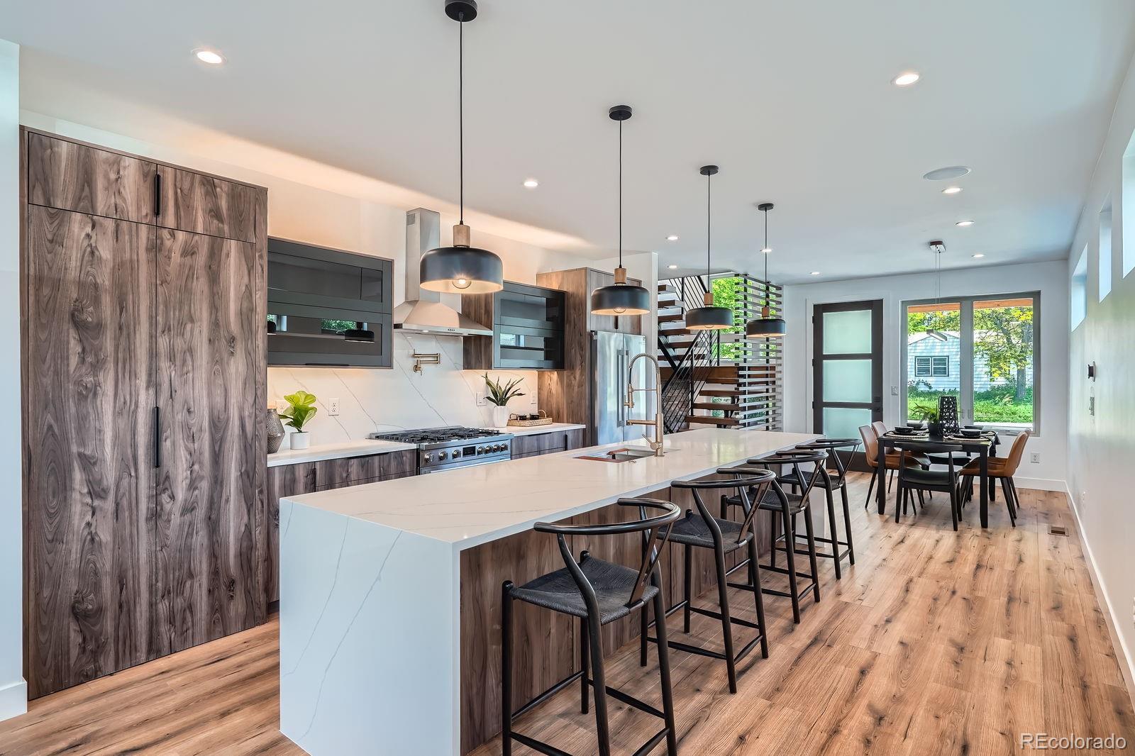 4474 Utica Street Denver, CO 80212 - Photo 6 of 40 a kitchen with stainless steel appliances granite countertop a refrigerator a oven a sink a dining table and chairs with wooden floor