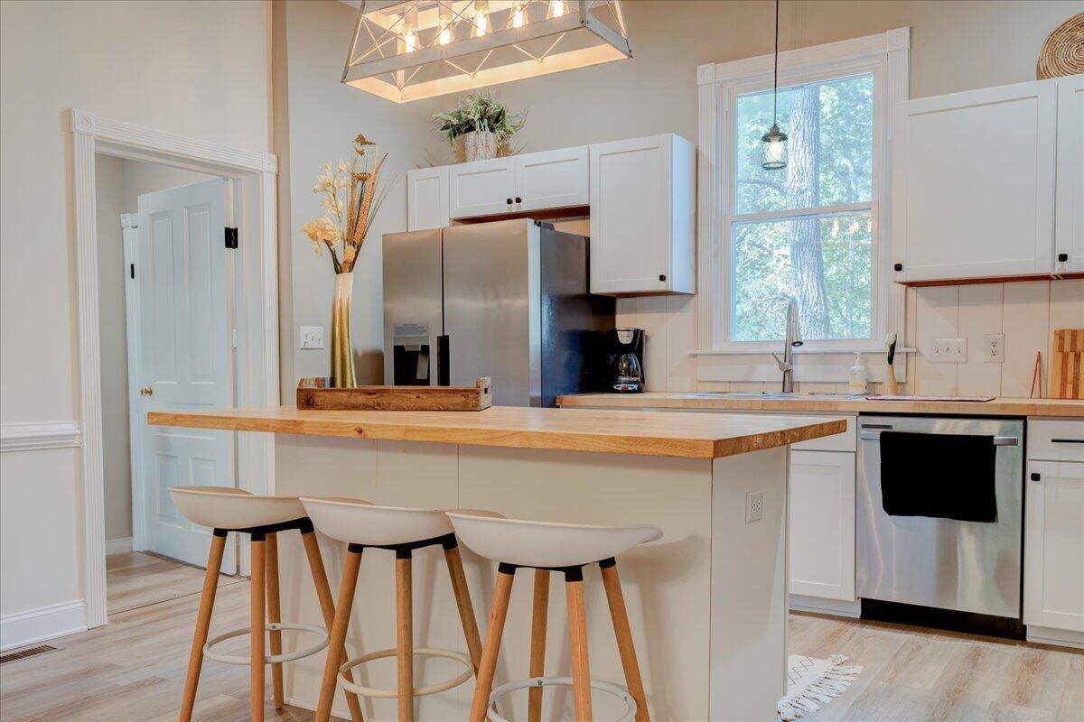 4534 Main Street Drakes Branch, VA 23937 - Photo 11 of 36 a kitchen with stainless steel appliances kitchen island a table chairs in it and wooden floors