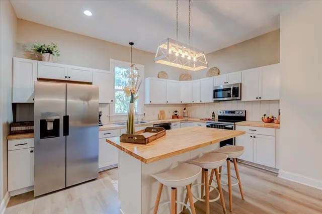 a kitchen with kitchen island granite countertop a center island a refrigerator cabinets a sink and a counter top space
