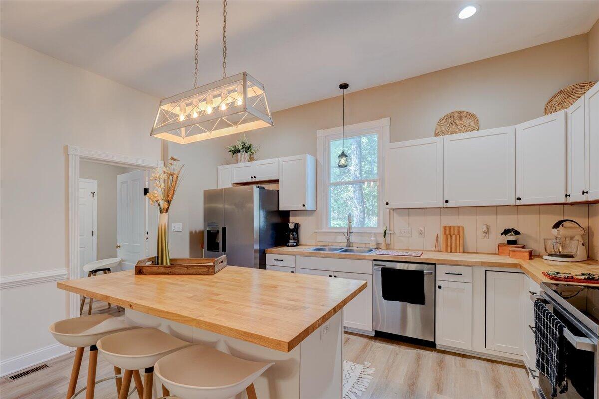 4534 Main Street Drakes Branch, VA 23937 - Photo 8 of 36 a kitchen with kitchen island a stove a table and chairs in it