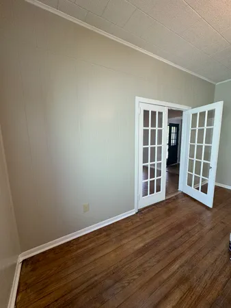 an empty room with wooden floor and workspace