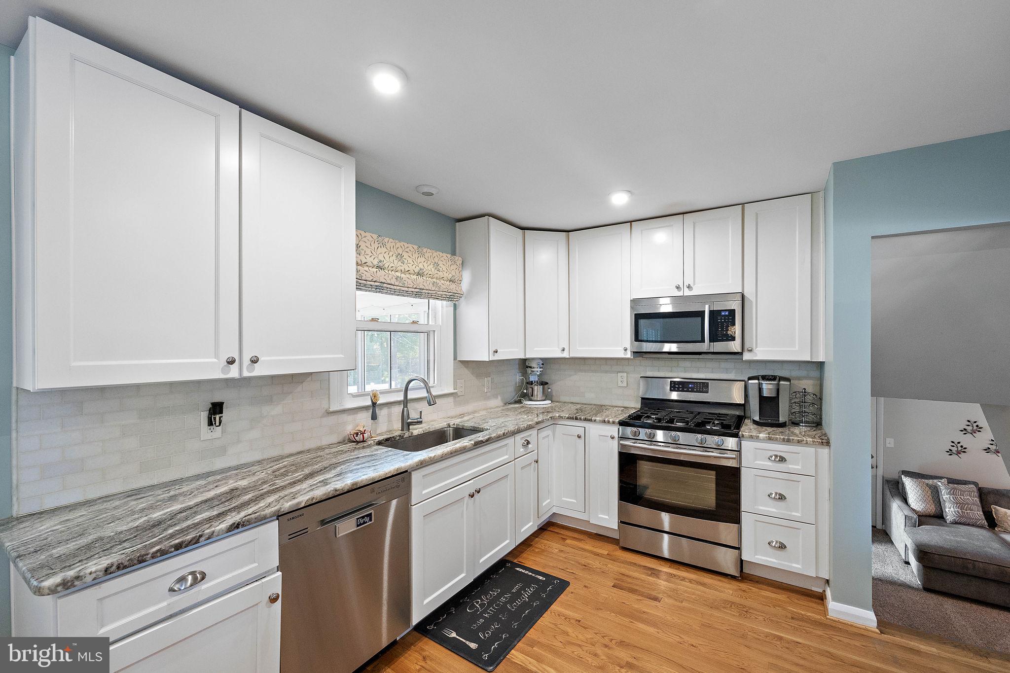 1010 Graylyn Road Wilmington, DE 19803 - Photo 10 of 32 a kitchen with kitchen island granite countertop a sink cabinets and stainless steel appliances