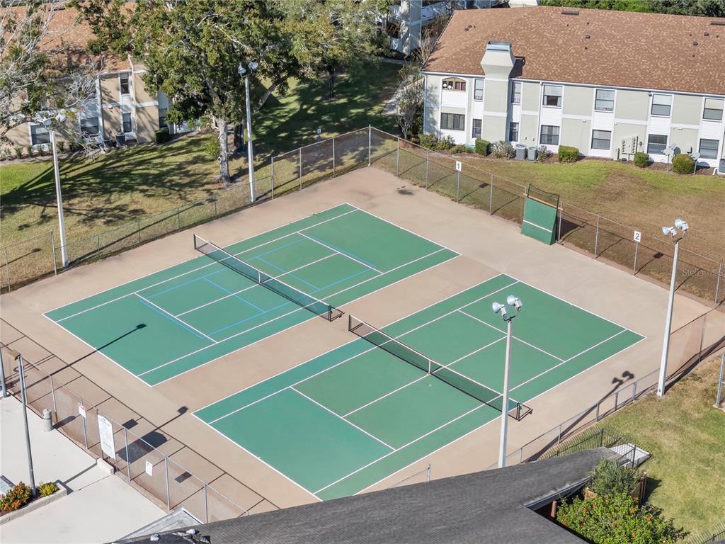 3286 South Semoran Boulevard, Unit 25 Orlando, FL 32822 - Photo 22 of 30 a view of a tennis ground with large trees