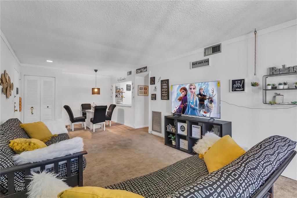 3286 South Semoran Boulevard, Unit 25 Orlando, FL 32822 - Photo 4 of 30 a living room with furniture and kitchen view