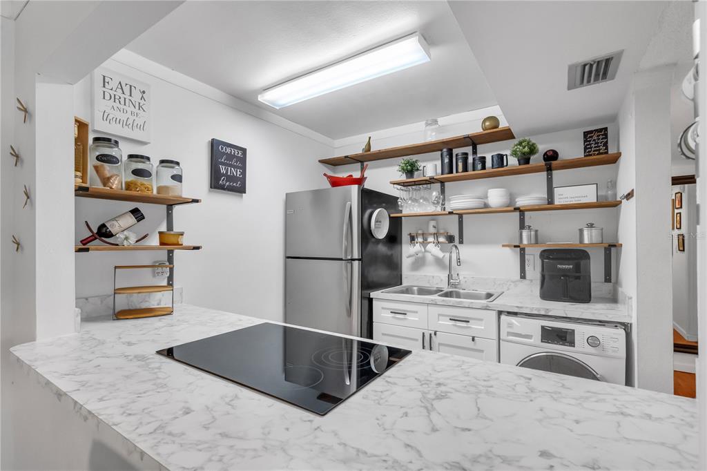 3286 South Semoran Boulevard, Unit 25 Orlando, FL 32822 - Photo 7 of 30 a kitchen with stainless steel appliances kitchen island granite countertop a refrigerator and a sink