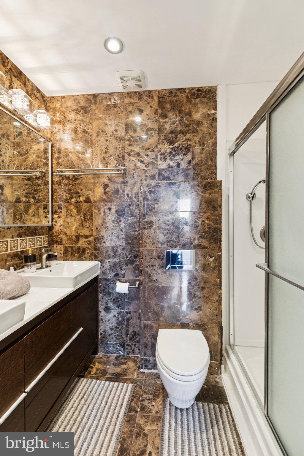 191 Presidential Boulevard, Unit R724 Bala Cynwyd, PA 19004 - Photo 9 of 19 a bathroom with a granite countertop toilet sink and a shower