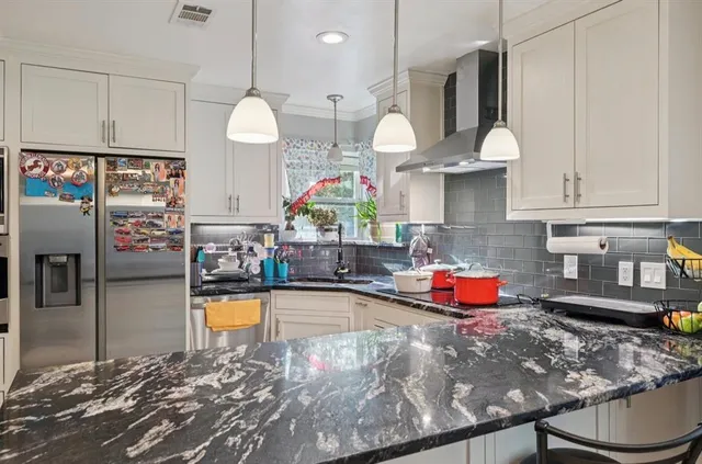 a kitchen with stainless steel appliances granite countertop a sink a stove and a wooden floors