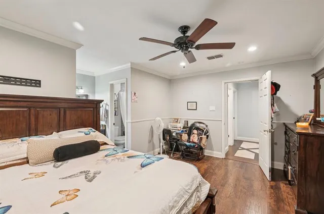 a bed room with a bed a dresser and a chandelier