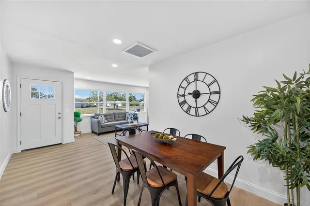 a kitchen with stainless steel appliances kitchen island granite countertop a refrigerator and a stove top oven with wooden floor