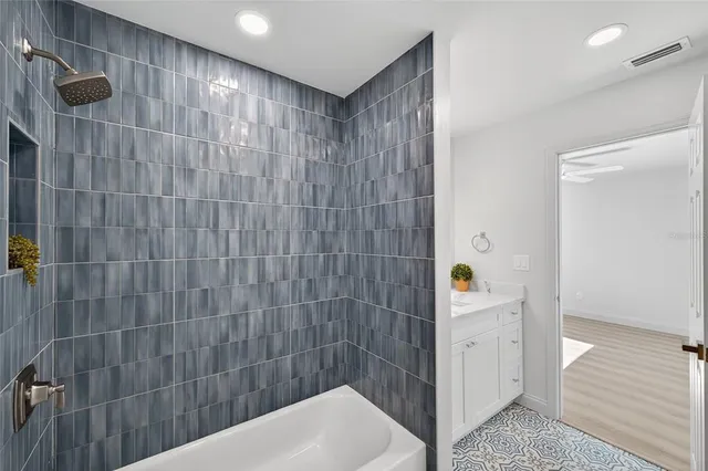 a view of a room with wooden floor and ceiling fan