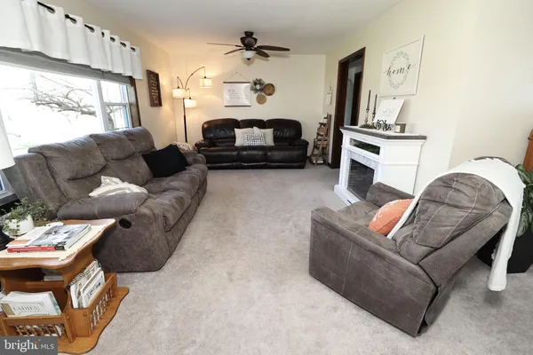 a kitchen with granite countertop a refrigerator a stove a sink a dining table and chair with wooden floor