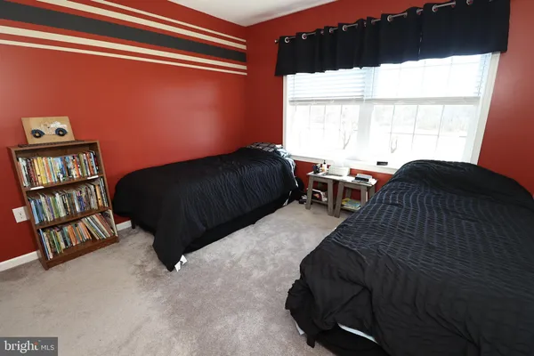 a living room with couches a table and a fireplace with wooden floor