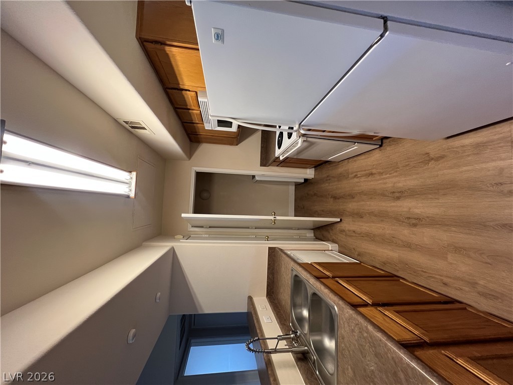 7255 West Sunset Road, Unit 2057 Las Vegas, NV 89113 - Photo 8 of 12 Compact and practical, this kitchen boasts wood cabinetry and durable countertops, providing an efficient culinary space.