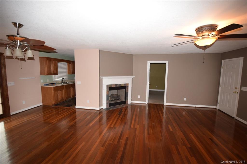 171 Hunters Trace Rutherfordton, NC 28139 - Photo 19 of 24 an empty room with wooden floor and fireplace