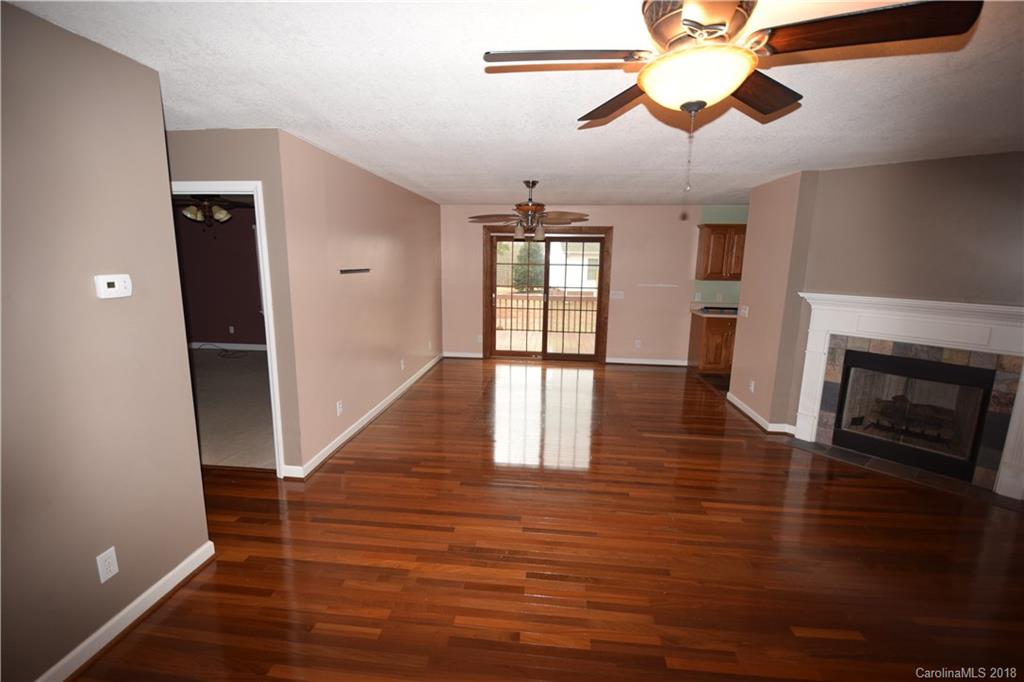 171 Hunters Trace Rutherfordton, NC 28139 - Photo 20 of 24 a view of an empty room with wooden floor fireplace and a window