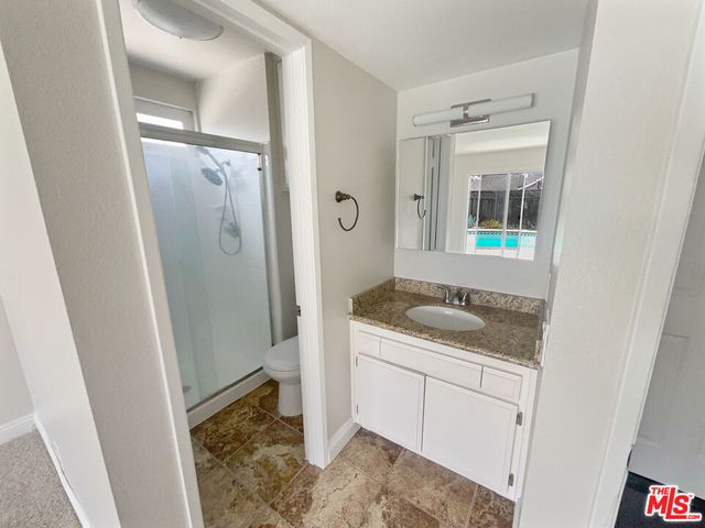 a bathroom with a granite countertop sink and a mirror