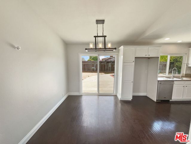 a view of a room with wooden floor a ceiling fan and a window
