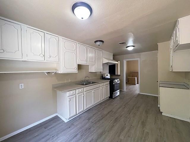 10 Pershing Drive, Unit A Denison, TX 75020 - Photo 5 of 15 a kitchen with stainless steel appliances granite countertop a stove top oven a sink a refrigerator white cabinets and wooden floor