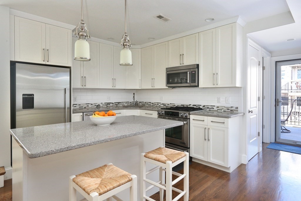 a kitchen with stainless steel appliances granite countertop a stove top oven a sink a counter space and cabinets