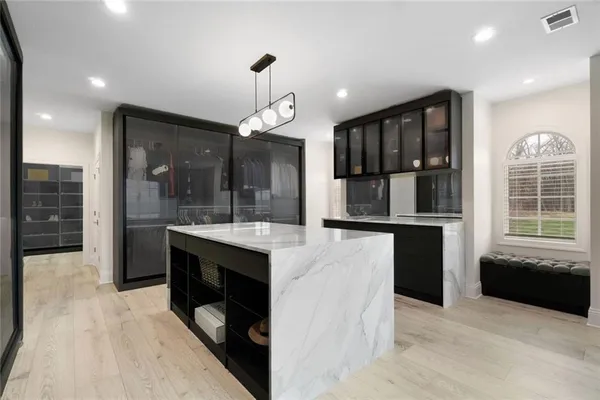 a kitchen with kitchen island a sink stainless steel appliances and cabinets